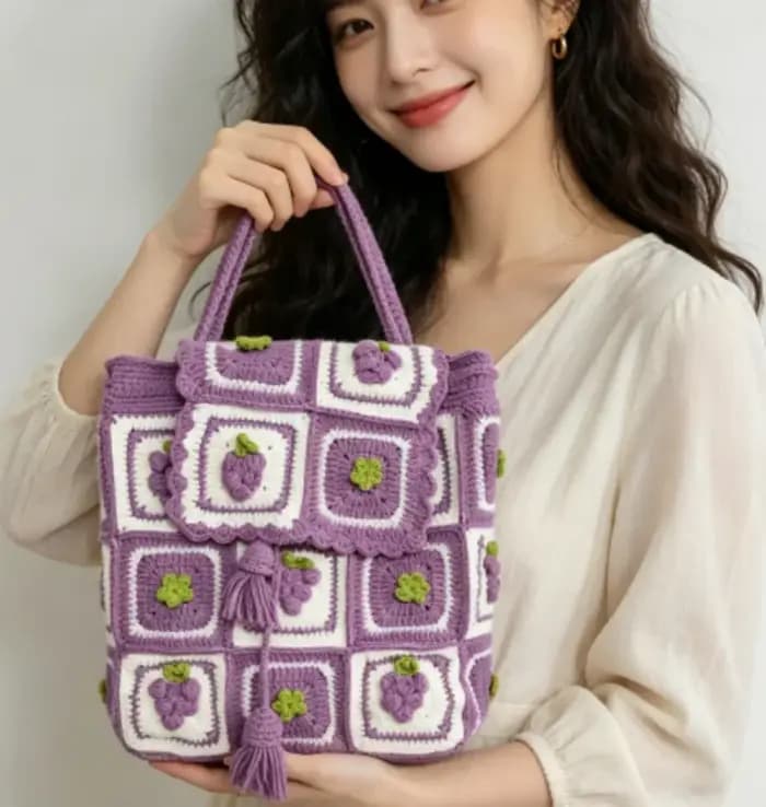 Sac à dos en laine crochetée fait main avec des motifs de cerises